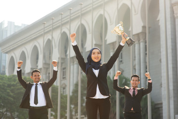 Muslim businesswoman holding a trophy
