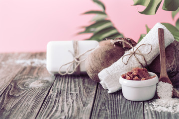 Spa and wellness setting with flowers and towels. Bright composition on pink background with tropical flowers. Dayspa nature products with coconut