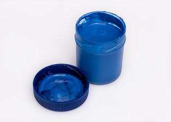 Opened blue Gouache jar, on white background with copy space. Cans of different colors gouache...