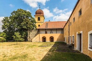 Panensky Tynec, Czech Republic - July 15 2019: Yellow bell tower and former monastery of Poor...