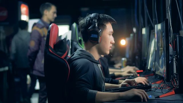 Men are sitting in front of computers and playing a network game