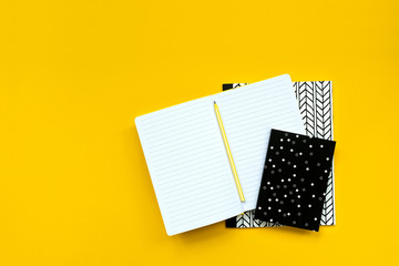 Back to school concept. School supplies: open notebook and pen on yellow background. Top view. Copy space. Flat lay. Mock-up