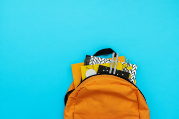 Fototapeta Back to school concept. Backpack with school supplies on blue background. Top view. Copy space. Flat lay obraz