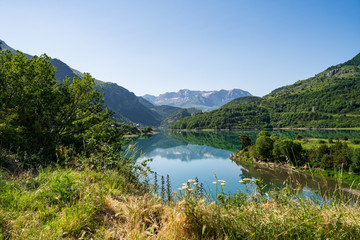 Fototapeta na wymiar Lanuza reservoir. Landscape of a reservoir surrounded by mountains on a sunny day.