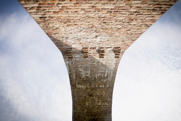 Arches of ancient stone bridge. The antique romanesque aqueduct. Bottom view.