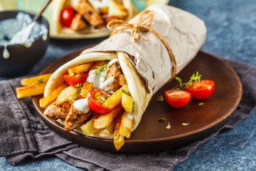 Gyros souvlaki wraps in pita bread with chicken, potatoes and tzatziki sauce.
