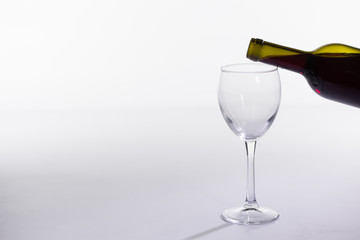 Red wine bottle pour glass on white background with copy space