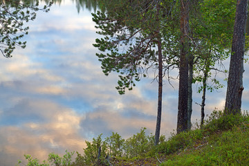 Picturesque sunset on Talvijarvi Lake in Ruka, Lapland, Finland. Mirror reflection