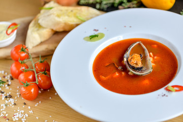 cream tomato soup with mussels on a round plate with beautiful food styling