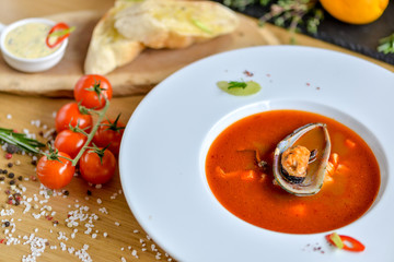 cream tomato soup with mussels on a round plate with beautiful food styling