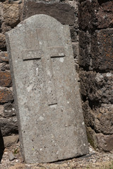 Pierre tombale appuy&eacute;e contre le mur d'une &eacute;glise