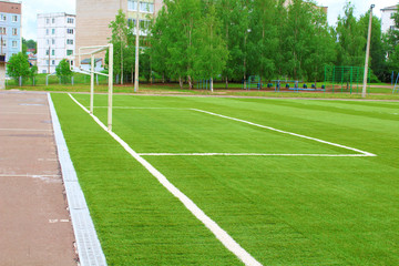 Fototapeta na wymiar New artificial football field. School stadium. Background.