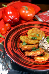 Ukrainian dish of deruni on a beautiful red plate in a restaurant on a table in a beautiful server