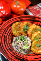 Ukrainian dish of deruni on a beautiful red plate in a restaurant on a table in a beautiful server