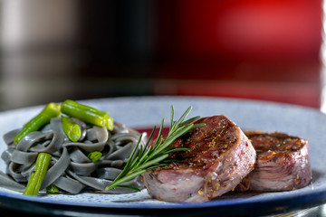two steaks of minignon on a plate in sauce