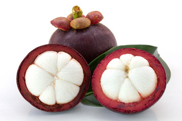 Ripe mangosteens (Garcinia mangostana) or half mangosteen with green leaves isolated on the white background.