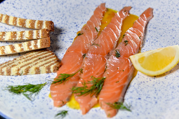 salmon sliced ​​with slicamis bruschetta on kartsugloy plate with lemon