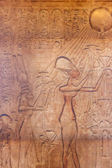 Ancient egyptian paintings and hieroglyphs carved on the stone wall