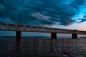 Fototapeta na wymiar Bridge over the Amur river at sunset. Russia. Khabarovsk. Photo from the middle of the river.