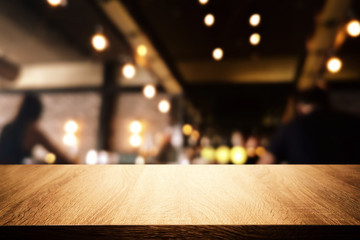 background Image of wooden table in front of abstract blurred restaurant lights