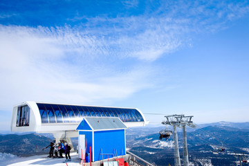 People on a lift and view of beautiful winter mountains.