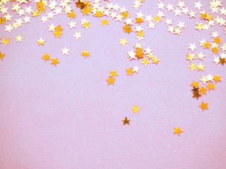 Golden stars glitter on lavender paper background