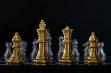 Golden chess are facing silver chess on black background. Business strategy, business competition, challenge or teamwork concept.