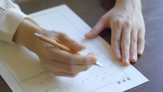 書類に記名する女性の手