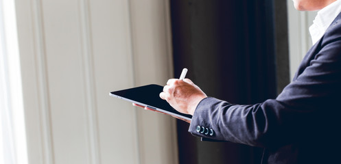 Asian business man using digital tablet in office to operate the network, e commerce online at the office, The media reaches the operational guidelines, for panoramic banner background with copy space