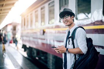 Asian man is traveler, he is waiting for their train. Outdoor adventure travel by train concept....