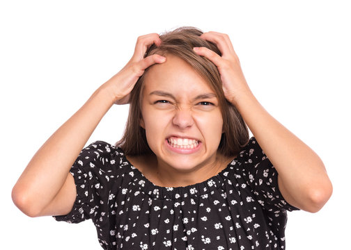Angry teen girl, isolated on white background. Human emotions, facial expression concept. Upset child looking furious and crazy rage, hold hands behind her head. Frustration, emotional portrait.
