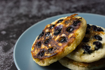 Blueberry pancake on a plate on dark background. Selective focus.