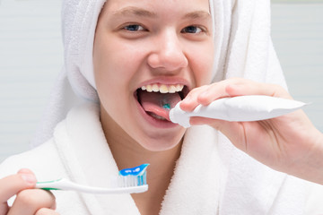 girl eating toothpaste from a tube in the bathroom