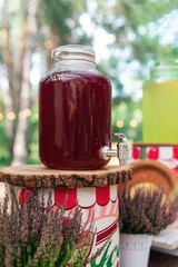 Glass jars of lemonade on wedding candy bar. Catering. Drinks on wedding party. Summer wedding in the forest
