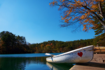 Vibrant autumn colors (foliage) at Goshiki-numa five colour pond. Row boat at port, Urabandai, Fukushima Prefecture, Japan