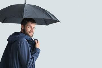 Handsome man with umbrella on white background