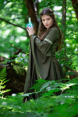 Elf with a bottle of magic potion in the forest