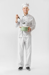 Handsome male chef with soup on white background