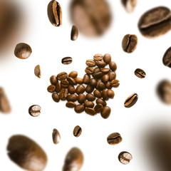 Coffee beans in the shape of a heart in flight on a white background