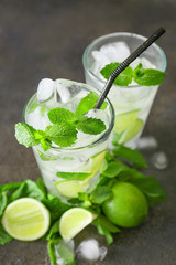 Glasses of fresh mojito on grey table