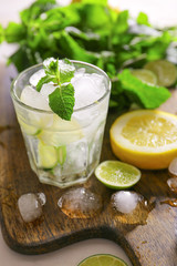 Glass of fresh mojito on wooden board