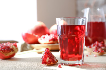 Glass of fresh pomegranate juice on table