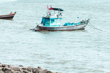 Naklejka premium Small blue fishing boat in the sea.