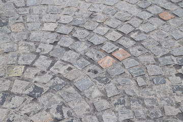 Closeup of vintage geometric stone blocks laying as floor of road.