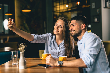 man and woman taking picture in cafeteria