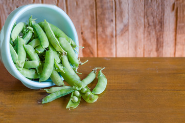Fresh green peas in a bowl on a wooden background. new crop. soft focus. copy space,  mock up.