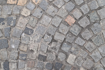 Closeup of vintage geometric stone blocks laying as floor of road.