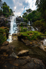 Fototapeta premium Wachirathan waterfall surrounded by lush tropical forest in Doi Inthanon National Park near Chiang Mai