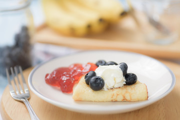 Banana pancakes on a wooden plate for breakfast in the summer