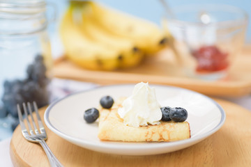 Banana pancakes on a wooden plate for breakfast in the summer